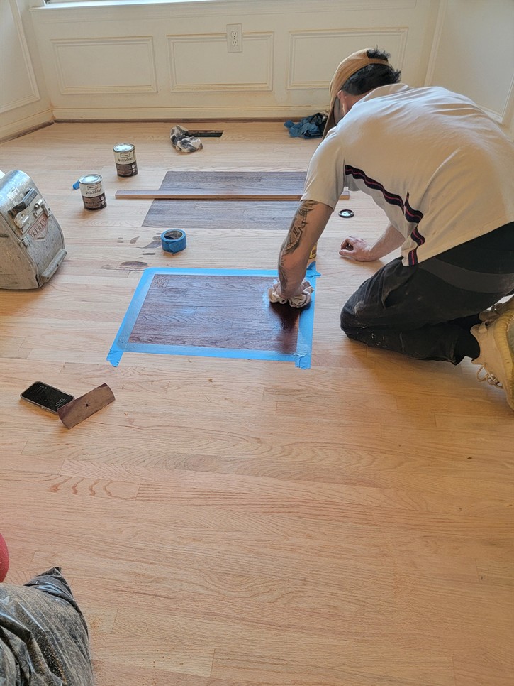 On-Site Stain Color Matching: Our expert refinishing technician creates test squares of stain directly on your floors, allowing you to choose the perfect color in person. No more guessing from small samples! Hardwood floor stain matching, refinishing services, accurate stain color, in-home flooring consultation, hardwood color test.